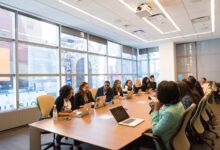A team in an office discussing proposal management during a meeting