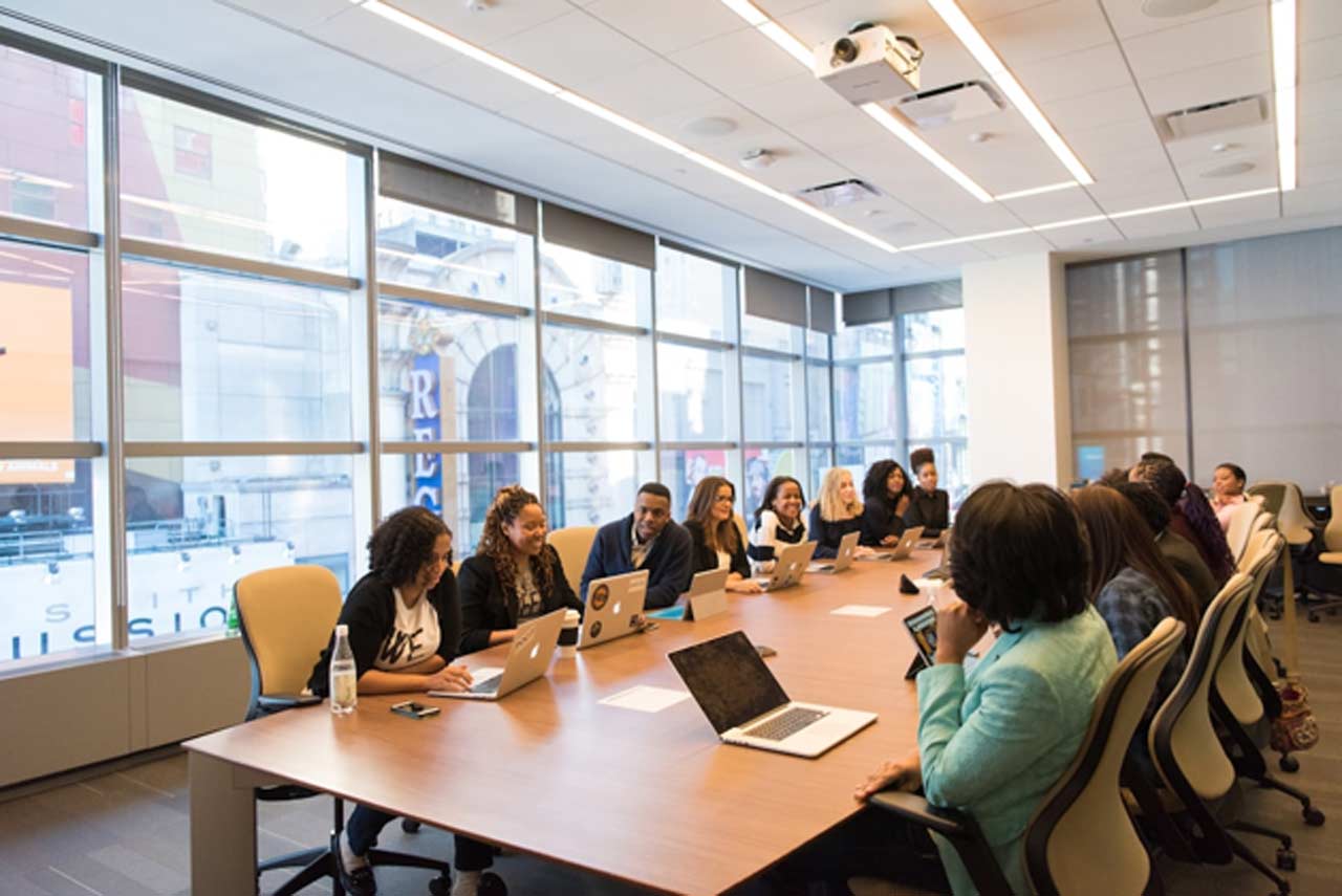 A team in an office discussing proposal management during a meeting